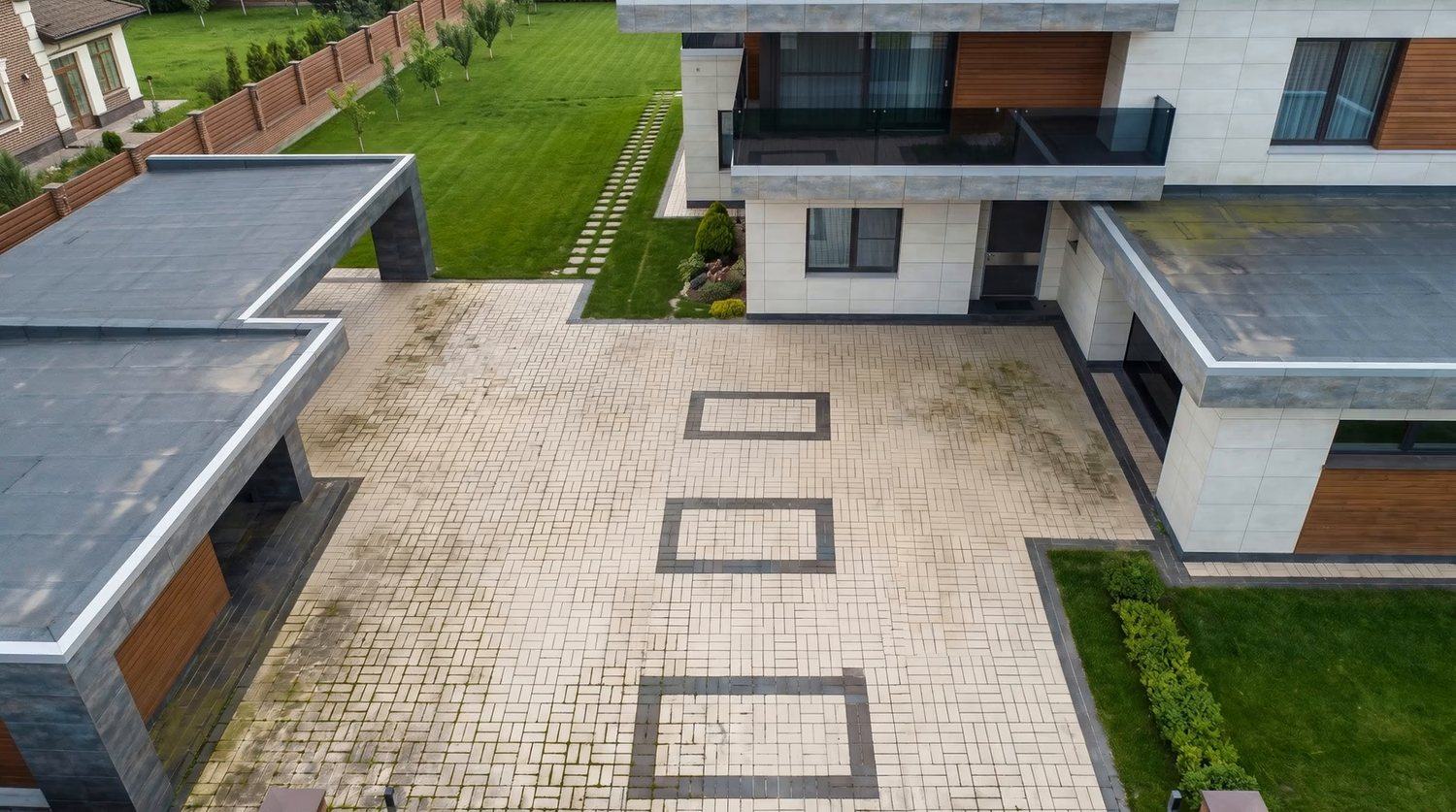 Oprit met lichte klinkerbestrating voor een woonhuis, het beginbeeld van de reiniging